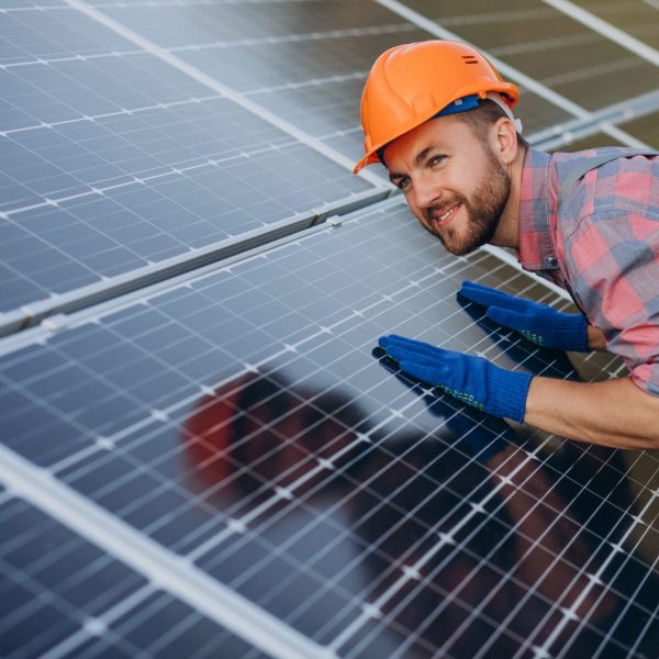 Male worker cleaning solar panels